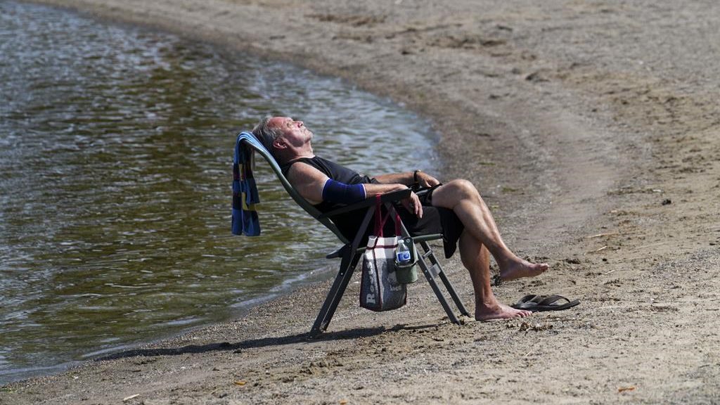 Duane relaxes on the banks of the Ottawa River in Ottawa on Tuesday, July 4, 2023. Several parts of Canada continue to swelter under intense heat, prompting weather warnings. THE CANADIAN PRESS/Sean Kilpatrick