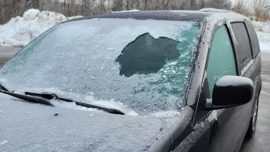 A windshield almost entirely covered in ice