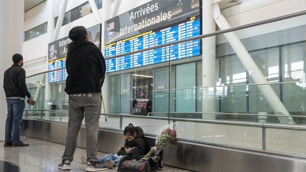 A person checking the arrivals and departures board at the airport.